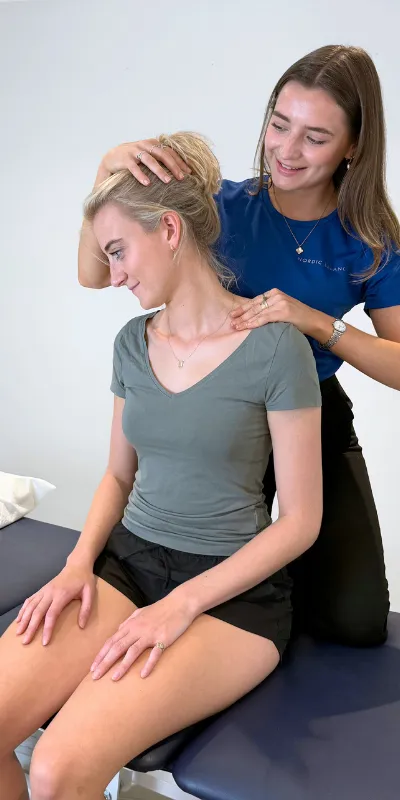 Nordic Balance practitioner assessing neck and shoulder movement during treatment.