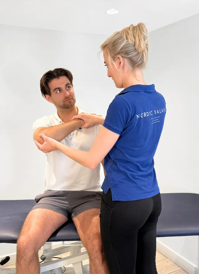 Nordic Balance physiotherapist assessing a patient’s shoulder movement during a clinical appointment.