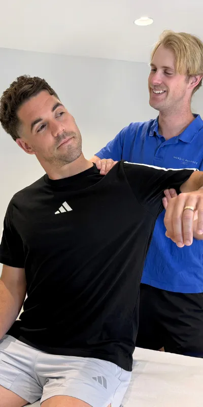 Nordic Balance practitioner assessing a patient’s shoulder movement during a clinical appointment.