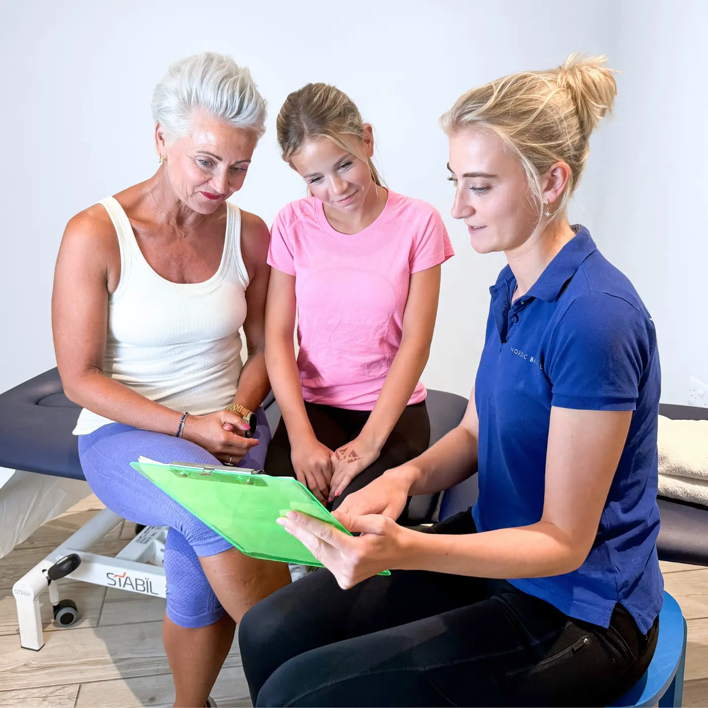 Paediatric osteopath at Nordic Balance discussing a teenager’s treatment plan with the teenager and her mother.