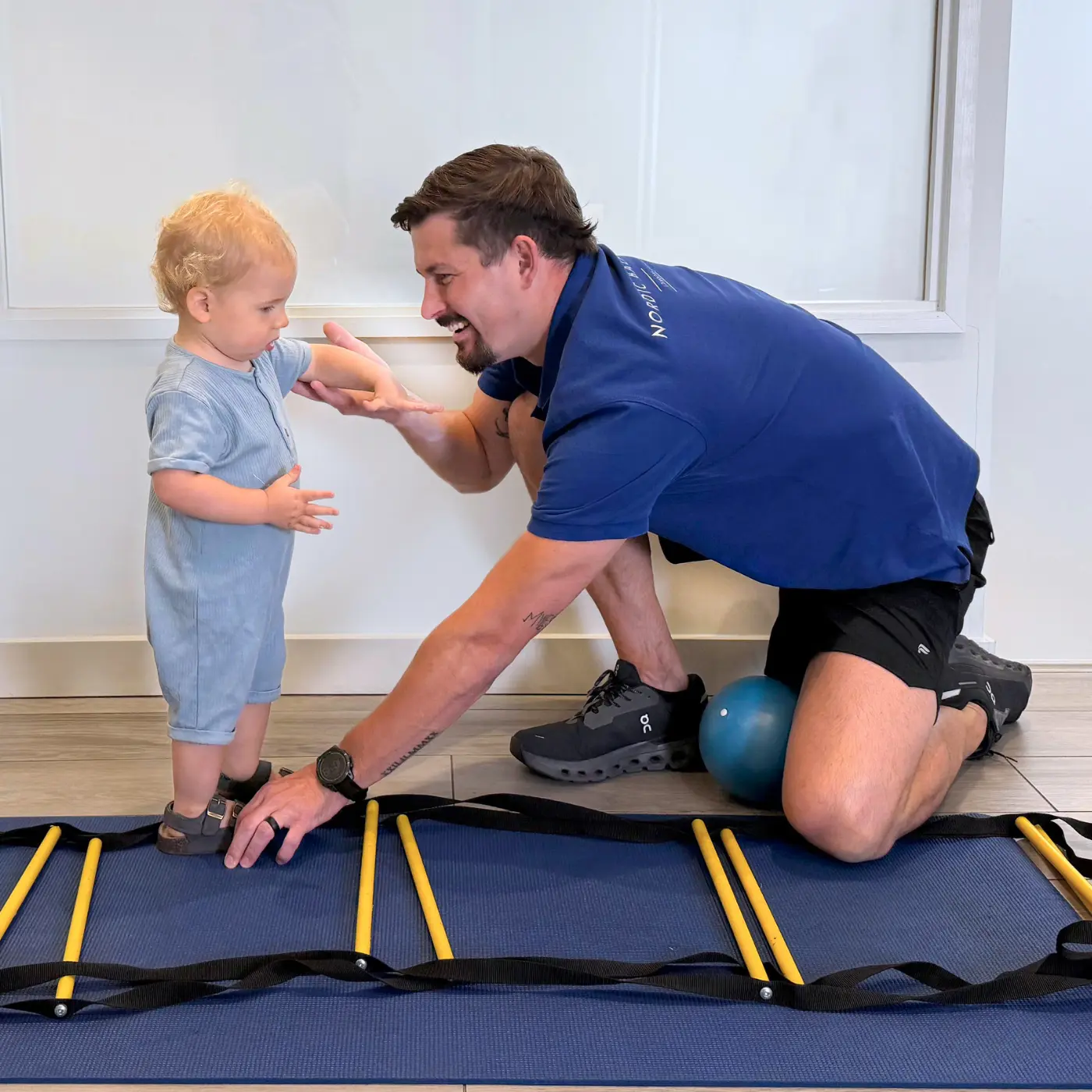 Paediatric osteopath at Nordic Balance assessing a toddler’s balance and coordination during a stepping exercise.