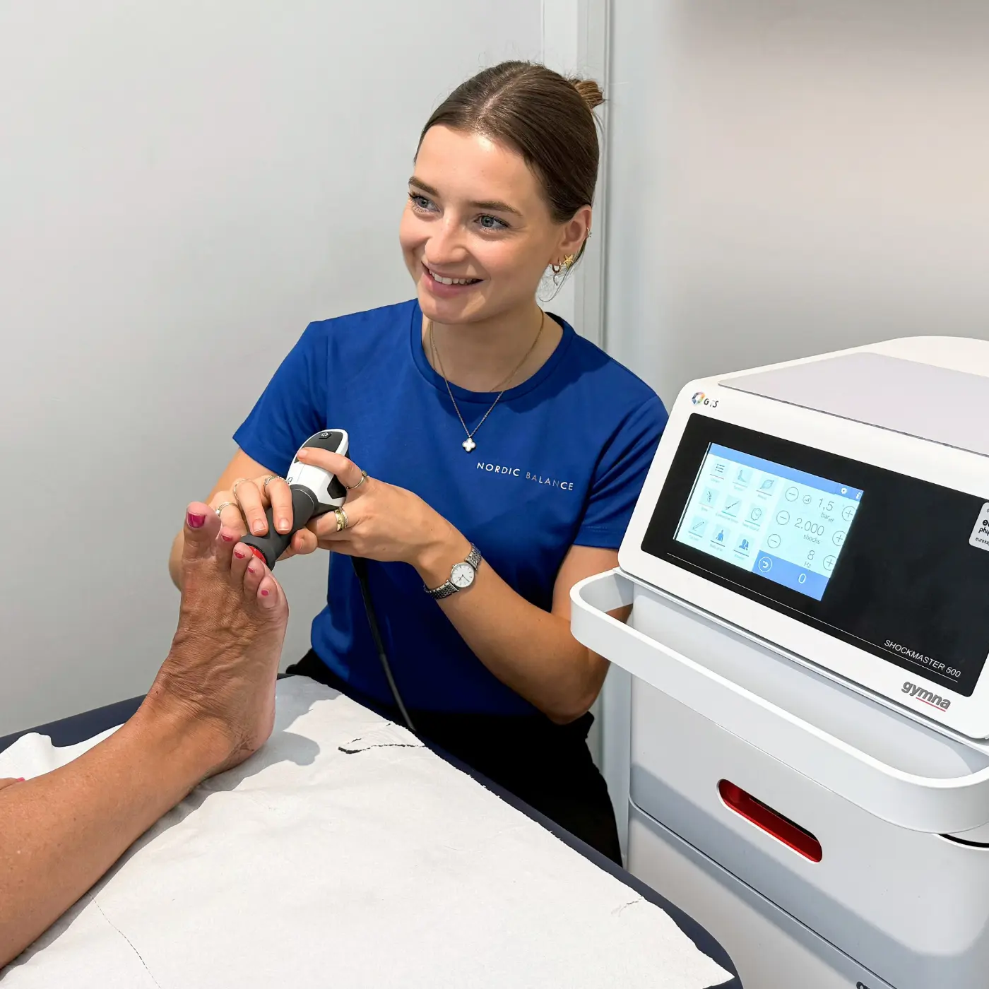 Shockwave therapy at Nordic Balance, with a therapist applying treatment to a patient’s foot using a shockwave device.