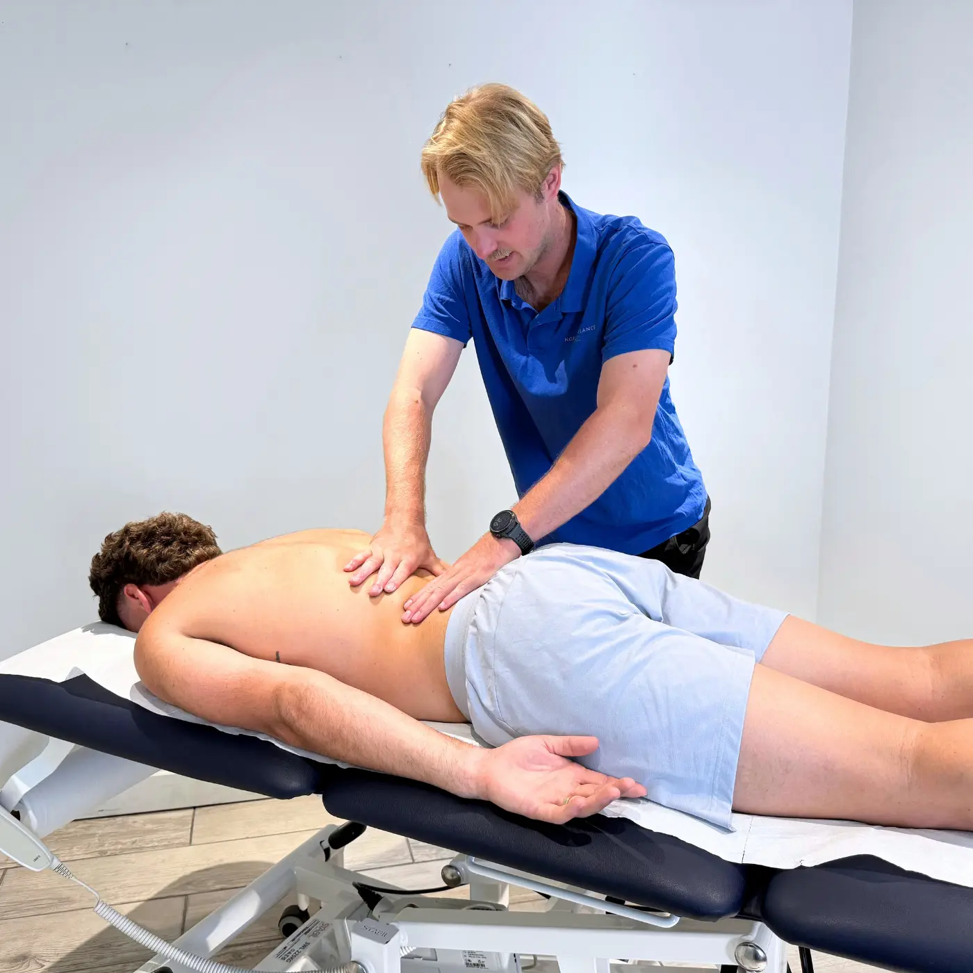 Sports massage therapist at Nordic Balance applying massage techniques to a man’s back to relieve muscle tension.