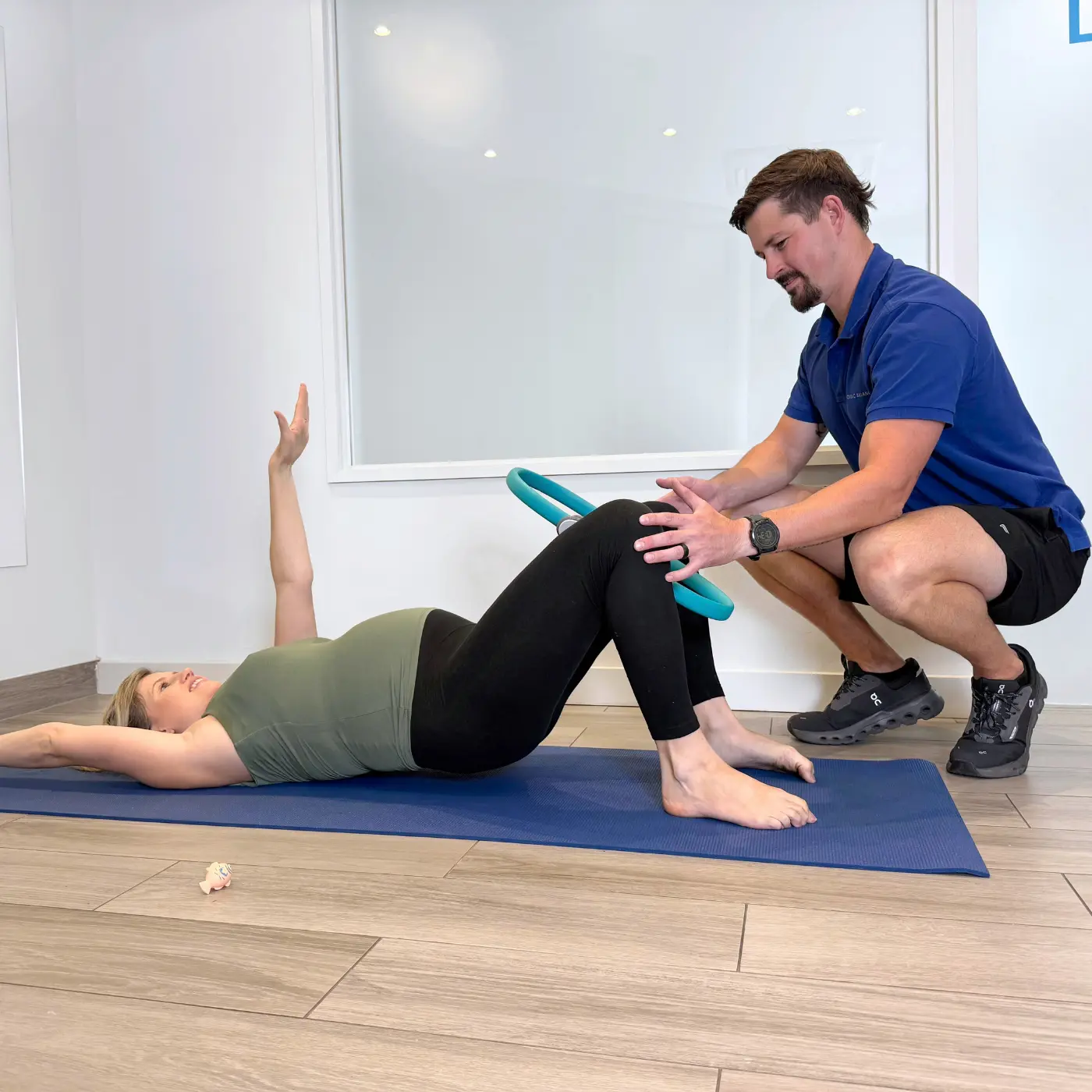 Women’s health physiotherapist at Nordic Balance guiding a pregnant woman through a pelvic floor rehabilitation exercise using a pilates fitness ring.