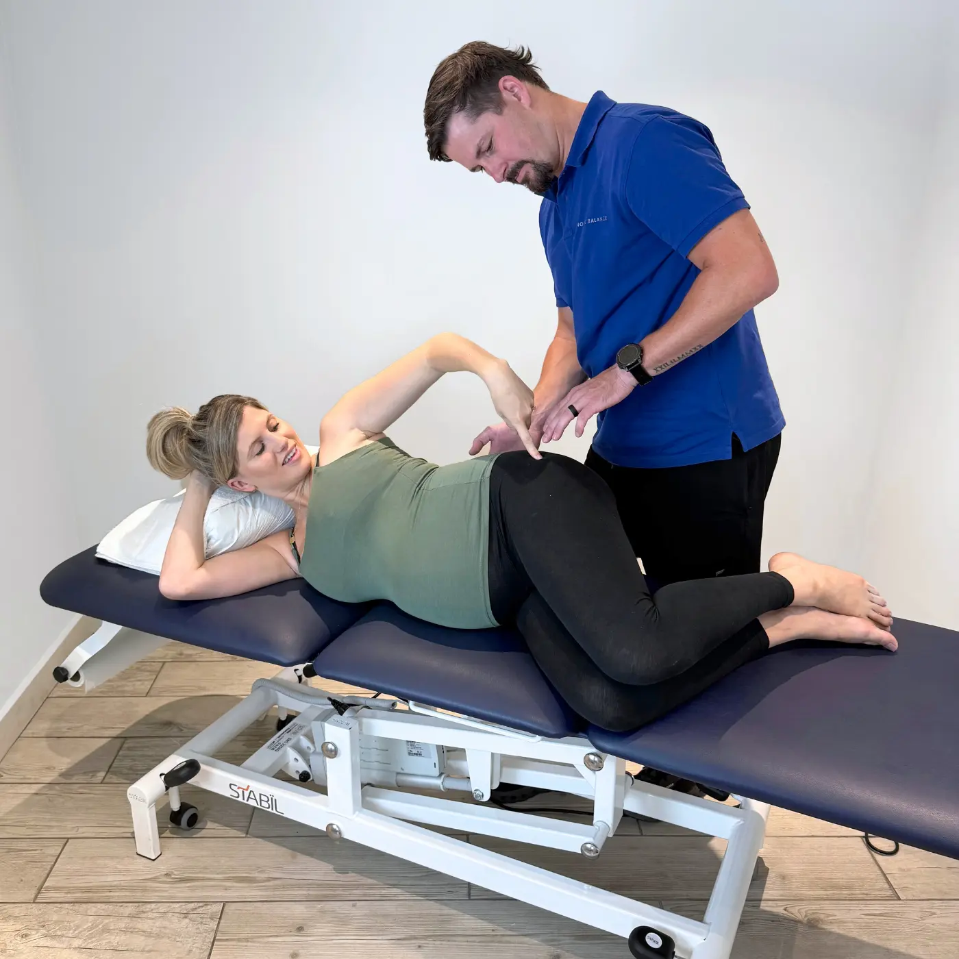 Physiotherapist at Nordic Balance assessing a pregnant woman’s movement and positioning during an examination.